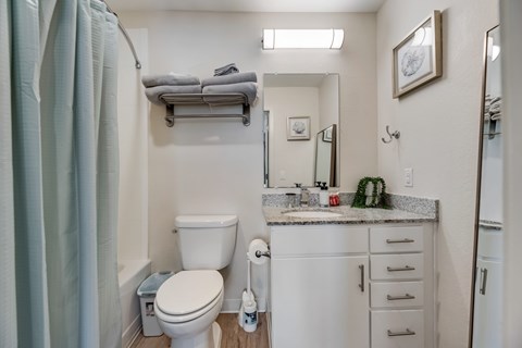 A small bathroom with a toilet, sink, and a mirror.