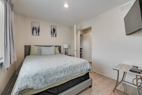 A bedroom with a bed, nightstand, and lamp.