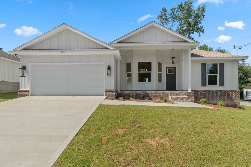 A white house with a grey garage door and a black front door.