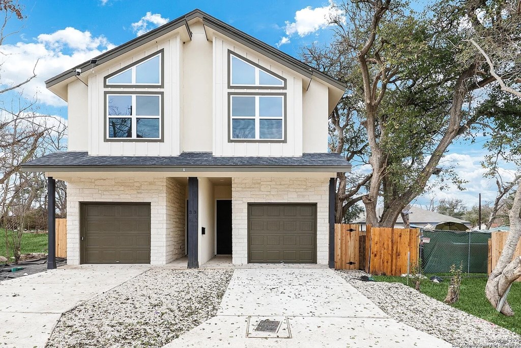 A modern house with a white exterior and a grey roof.
