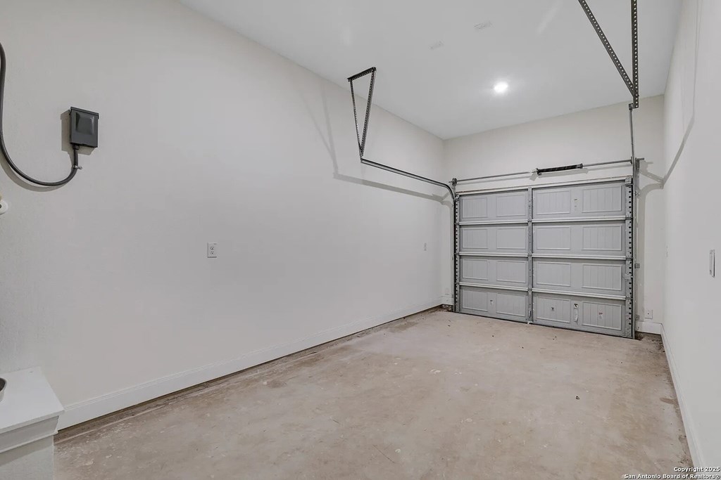 A garage with a white wall and a white door.