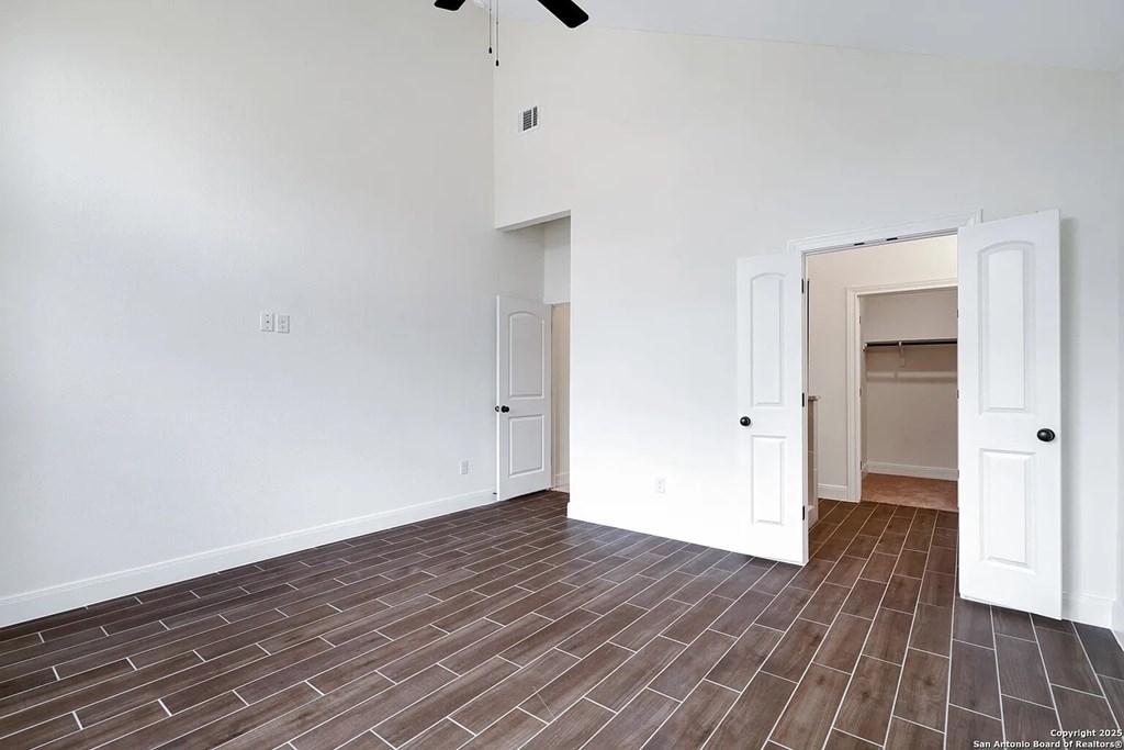 A room with a brown floor and white walls.