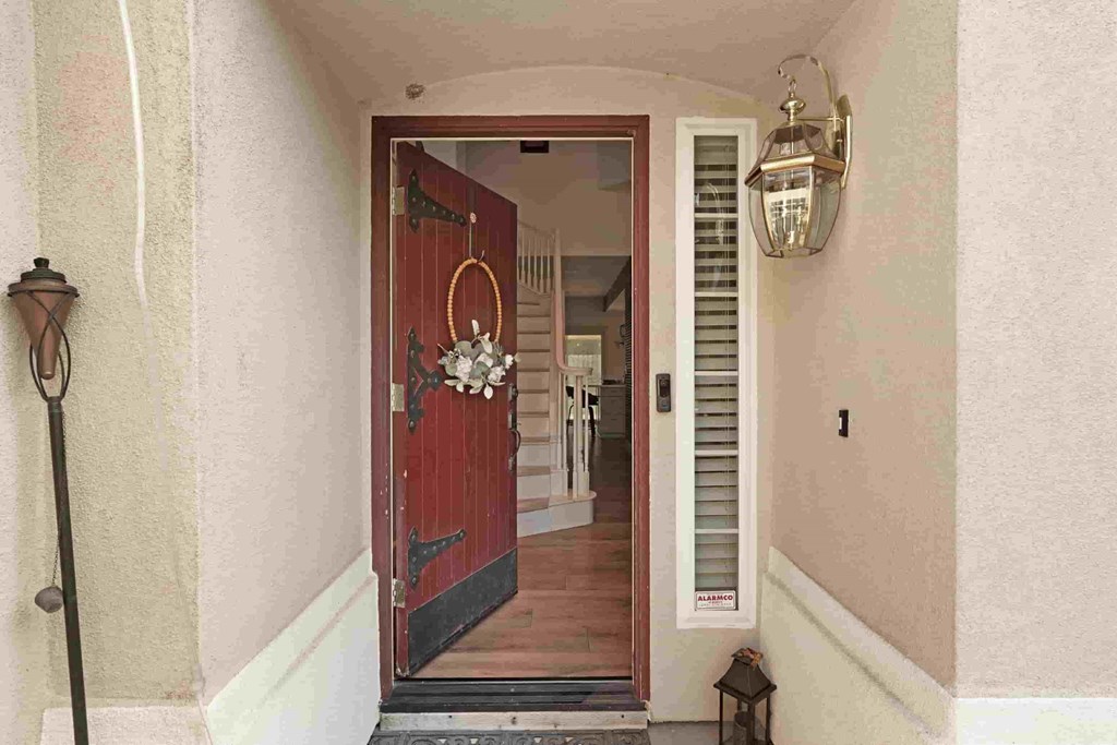 A red door is open to a hallway.