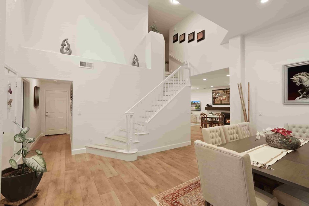 A white interior with a staircase and a dining table.