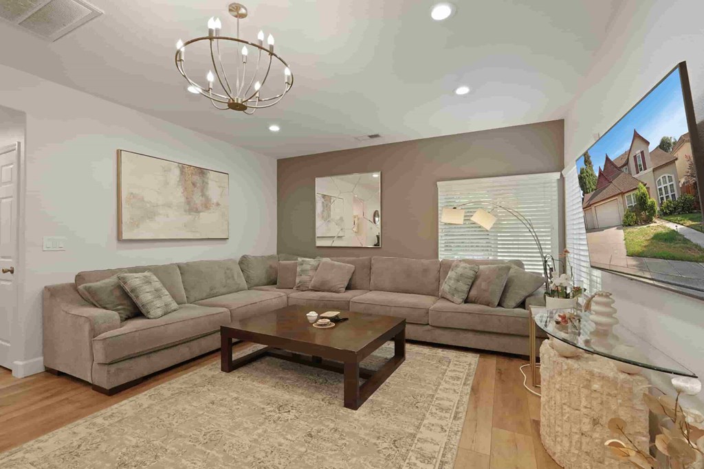 A living room with a couch, coffee table, and a painting on the wall.