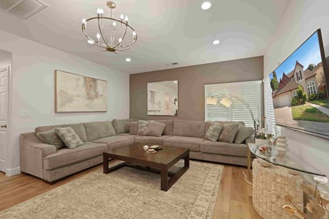 A living room with a couch, coffee table, and a painting on the wall.