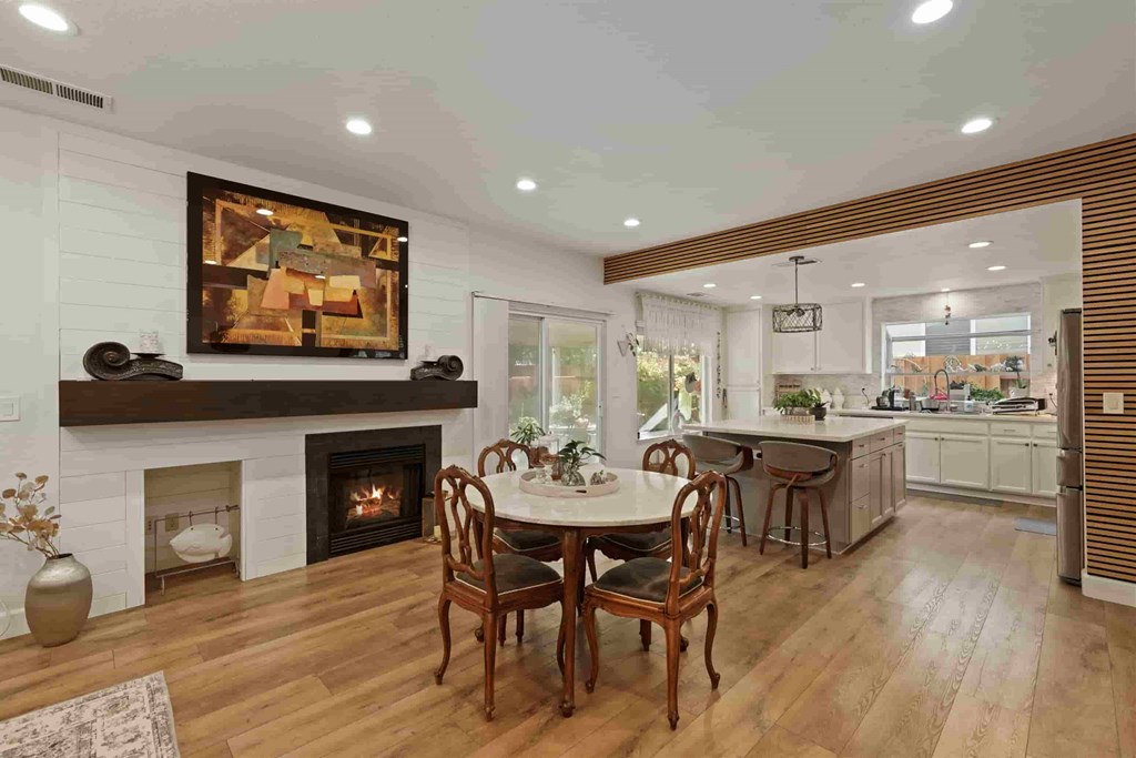 A dining room with a fireplace and a painting on the wall.