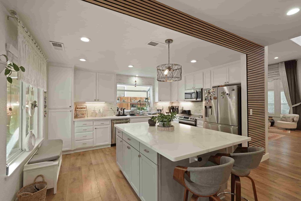 A modern kitchen with a large island and wooden floors.