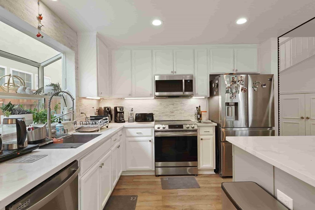 A modern kitchen with stainless steel appliances and white cabinets.