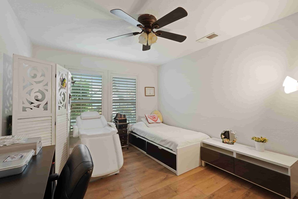 A room with a bed, a desk, and a chair.