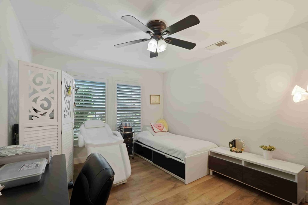 A bedroom with a bed, desk, and chair.