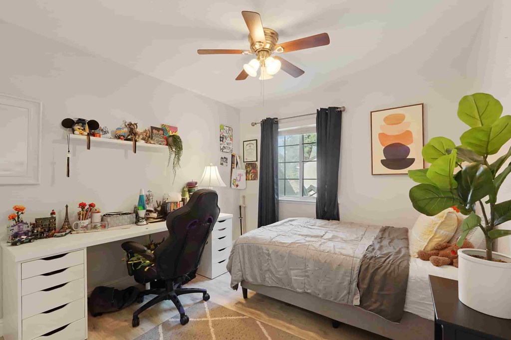 A room with a bed, desk, and chair.