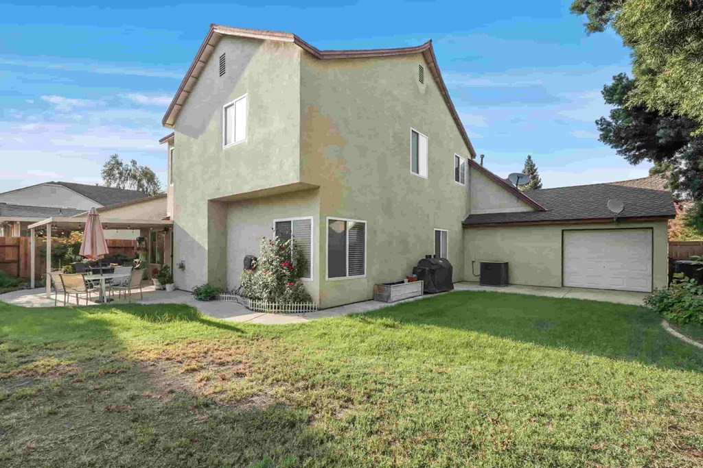A house with a green lawn and a white garage door.