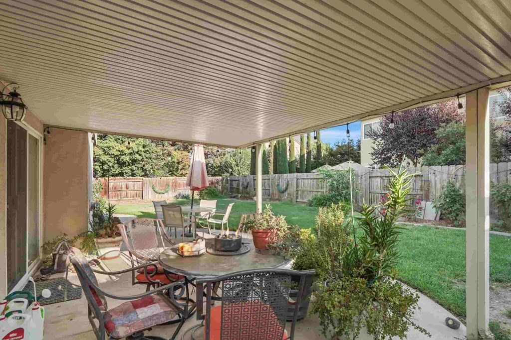 A patio with a table and chairs under a white awning.