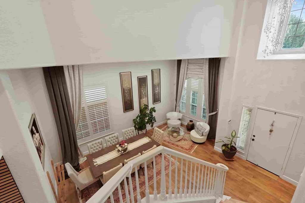 A dining room with a table set for two and a potted plant on the floor.