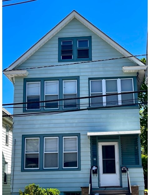A two story house with a white door and windows.