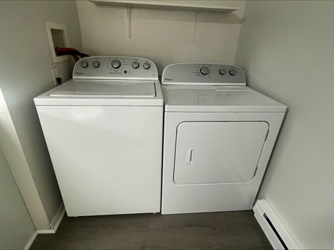 A white washing machine and dryer in a small laundry room.