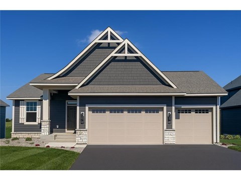 A house with a grey roof and a white garage door.