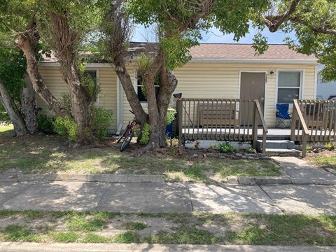 A small house with a brown door and a porch.