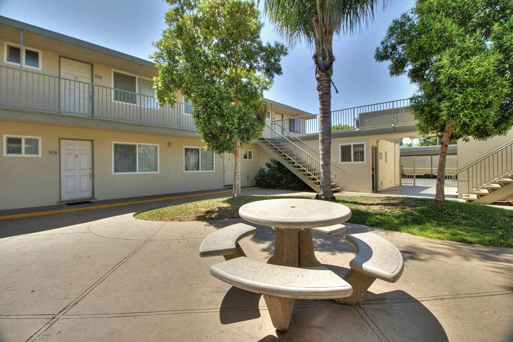 a picnic table in the courtyard of an apartment building