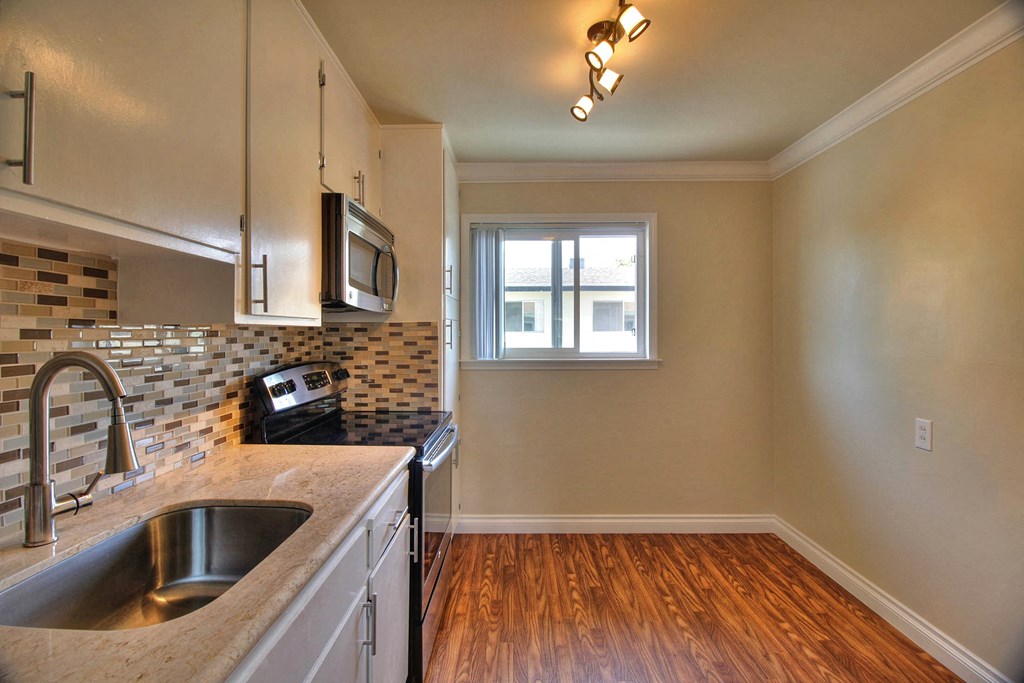 an empty kitchen with a sink and a window