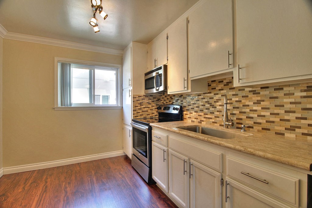a kitchen with white cabinets and a counter top