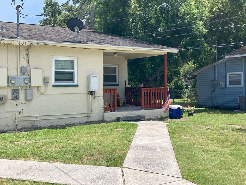 A house with a red door and a satellite dish on the roof.