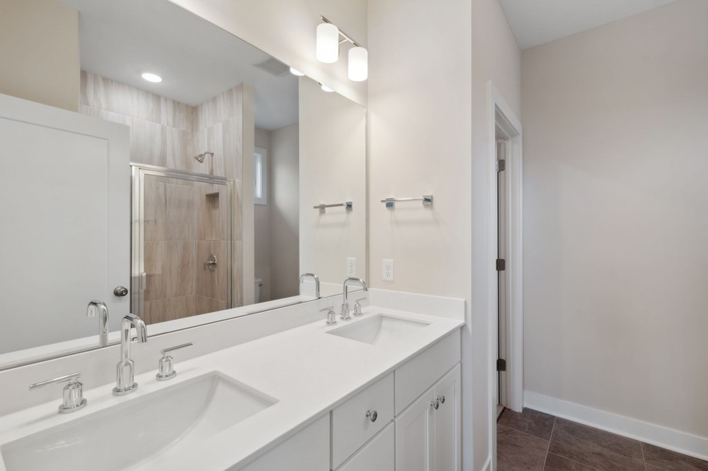 A bathroom with a white sink and mirror.