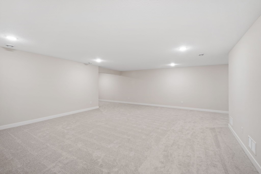 A spacious room with a carpeted floor and white walls.