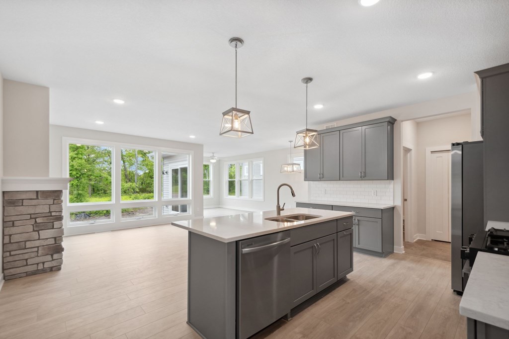A modern kitchen with a large island and a fireplace.