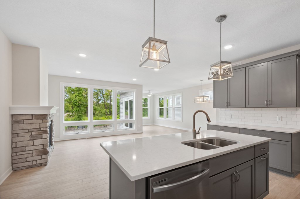 A modern kitchen with a large island and a fireplace.