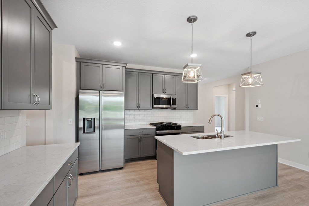 A modern kitchen with a large island and stainless steel appliances.