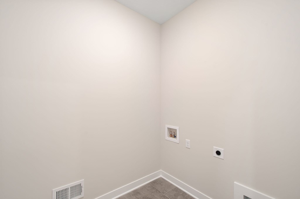 A small picture hangs on a wall above a baseboard.