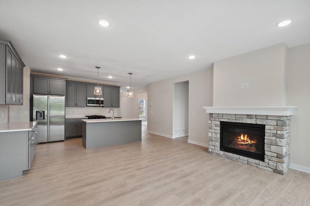A modern kitchen with a fireplace in the living room.