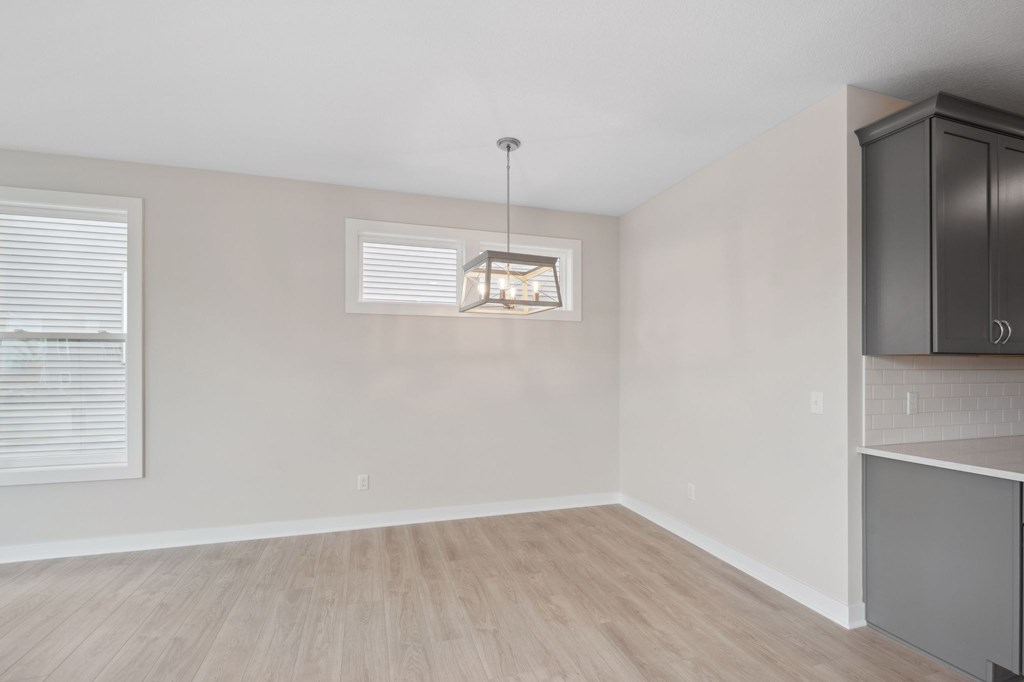 A room with a wooden floor and a cabinet on the right side.