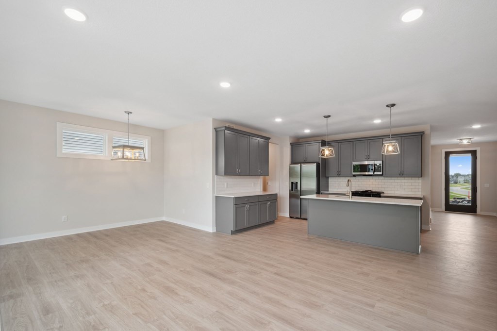 A spacious kitchen with a large island and a television.