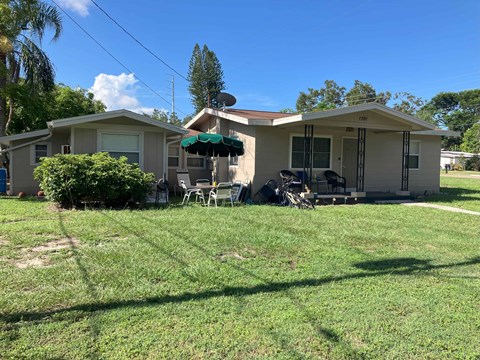 A house with a patio and a lawn in front.