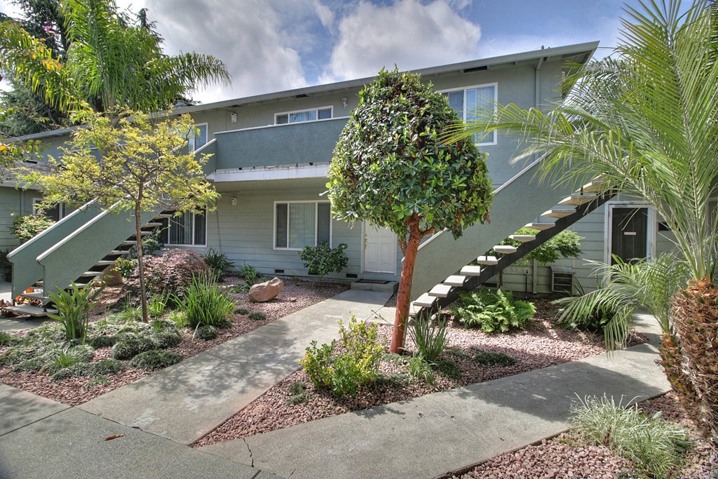a house with stairs and a garden in front of it