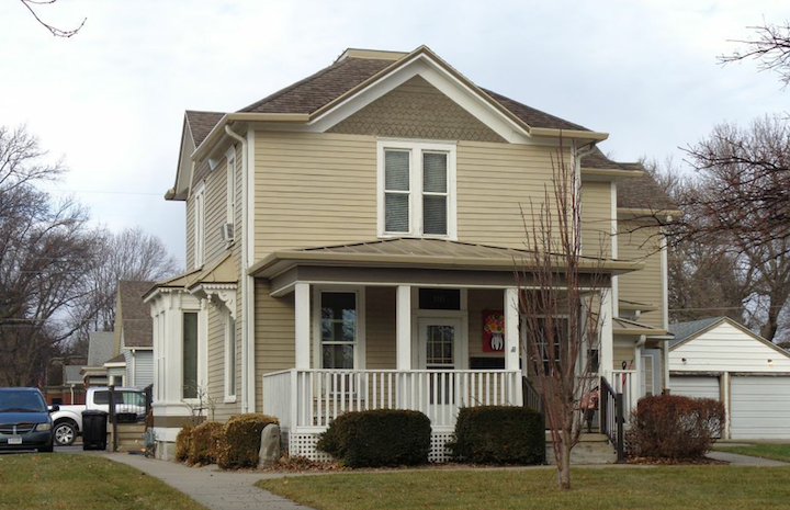 A house with a grey roof and a white fence.