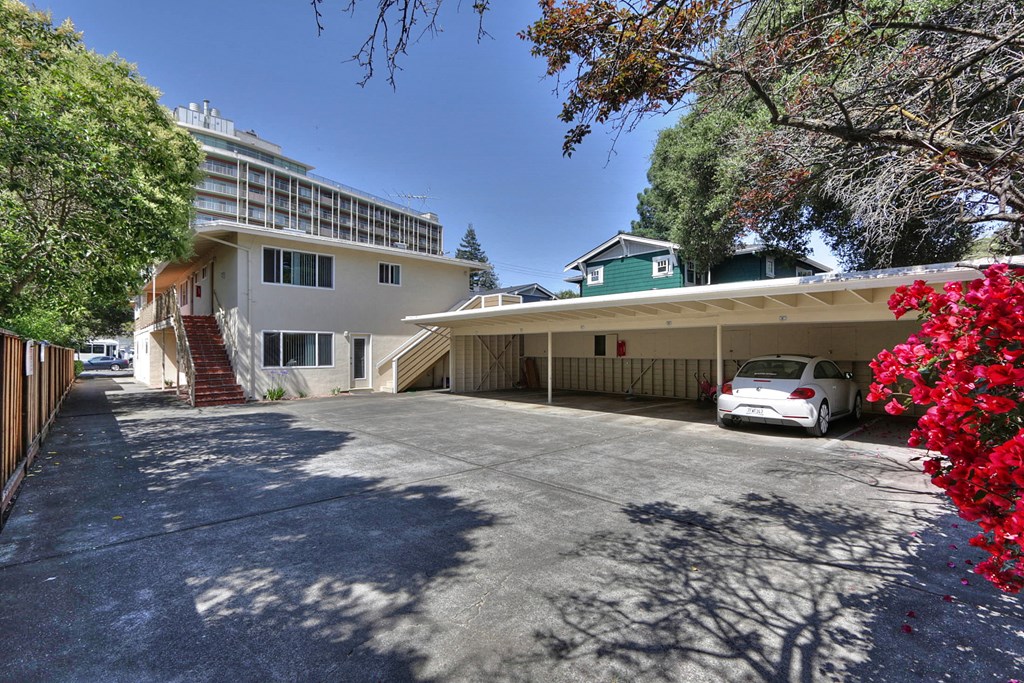 a parking lot with a white car in front of a building