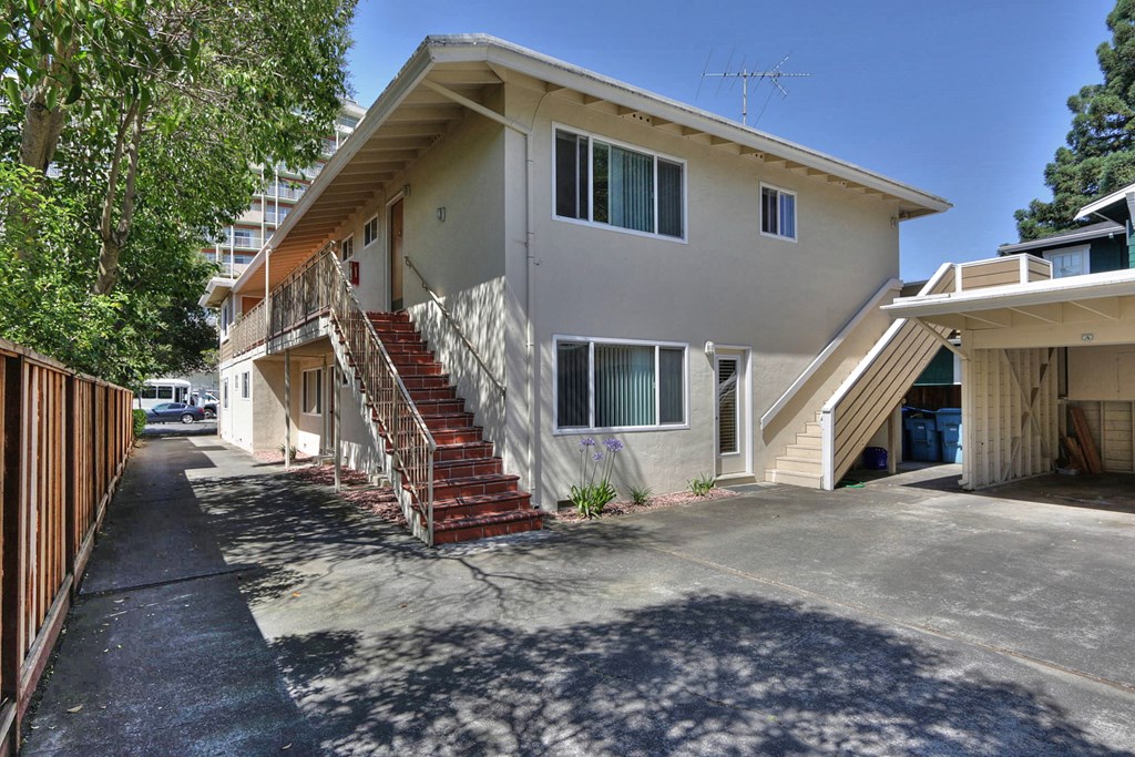 an apartment building with stairs and a driveway