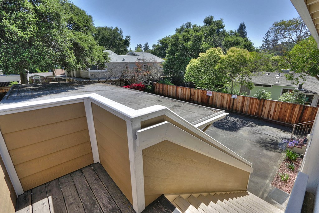 a deck with a roof and a backyard with trees