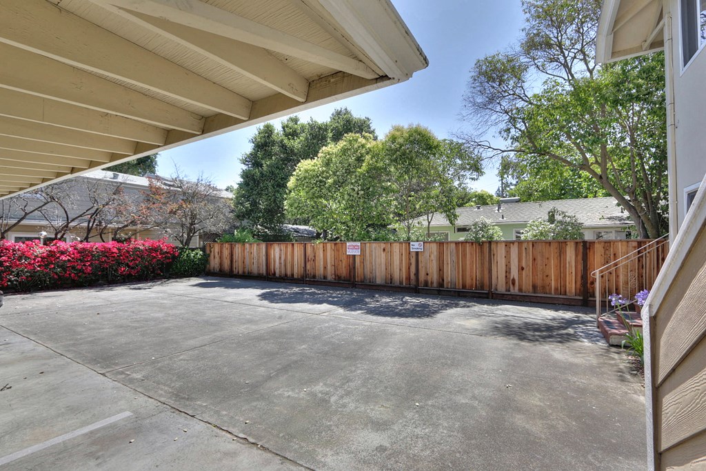 the driveway of a house with a wooden fence