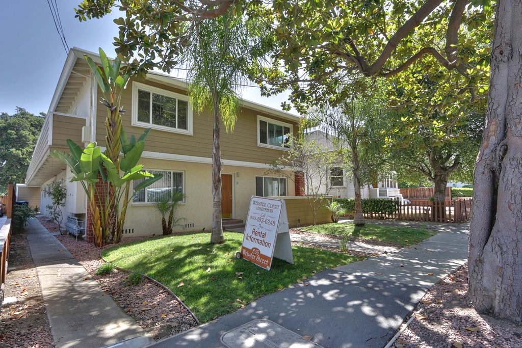 a house with a sign on the lawn in front of it