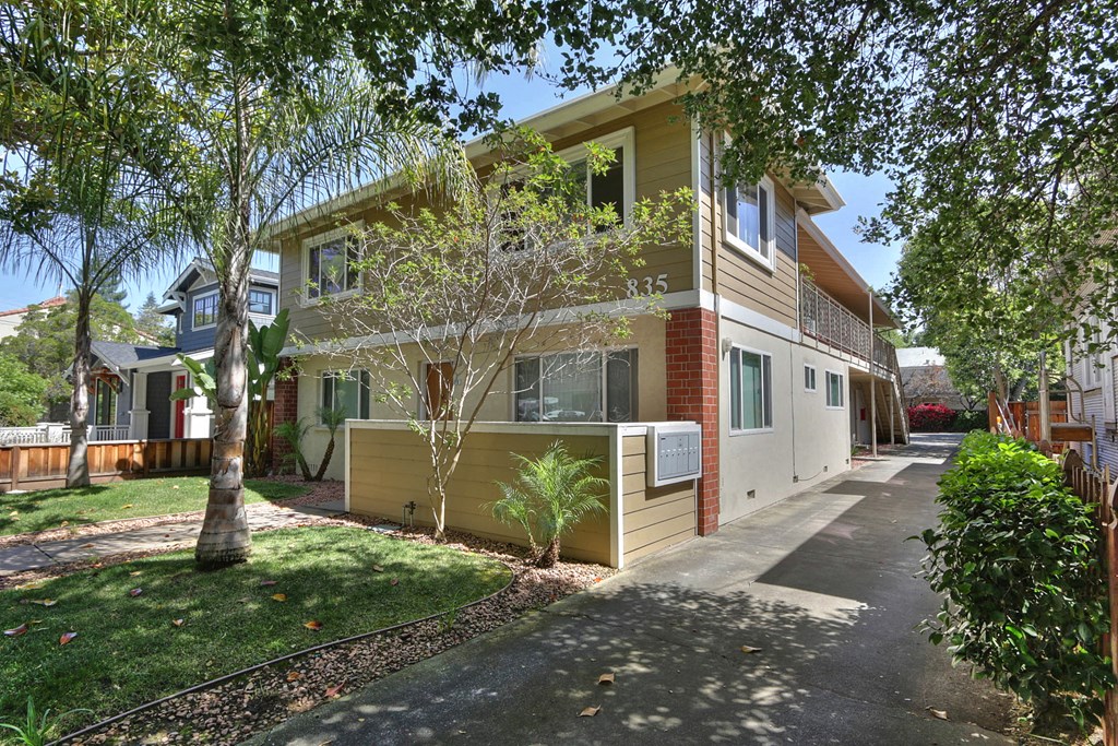 a yellow house with a sidewalk in front of it