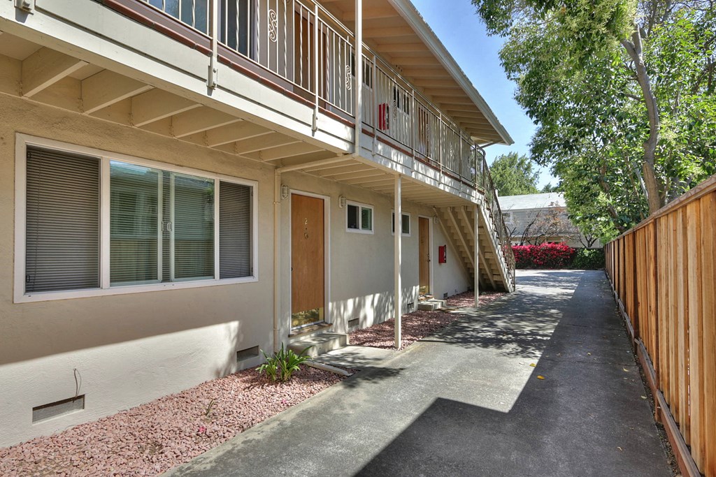 the front entrance of a building with a porch and a driveway