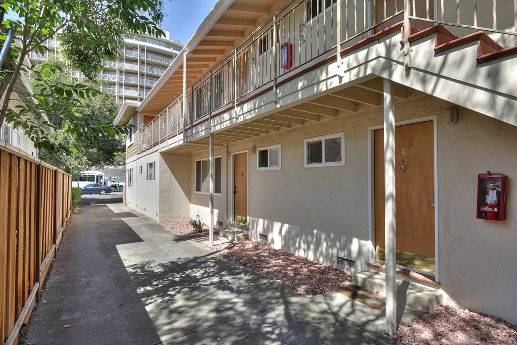 an apartment building with a sidewalk and a fire hydrant