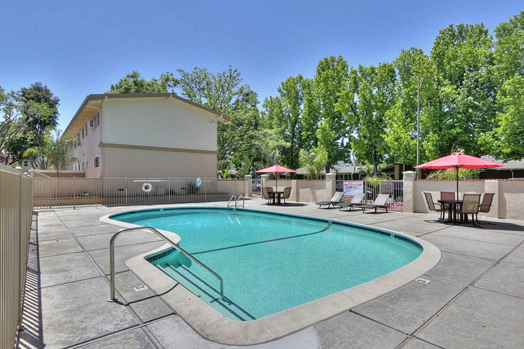 A small pool with a slide in the middle of a patio.