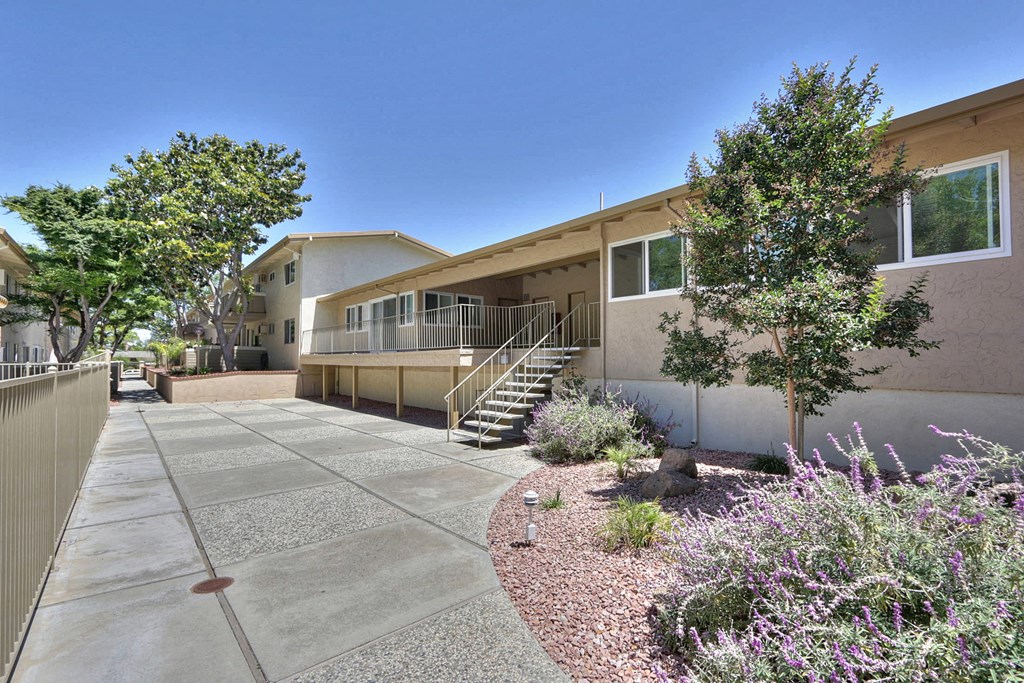 A building with a concrete walkway in front of it.