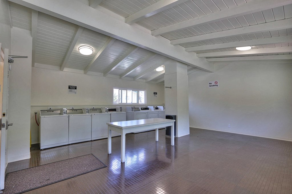 A large, empty room with a table and chairs in the center.